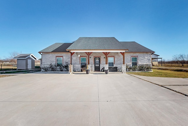 view of front of home featuring a storage shed and covered porch