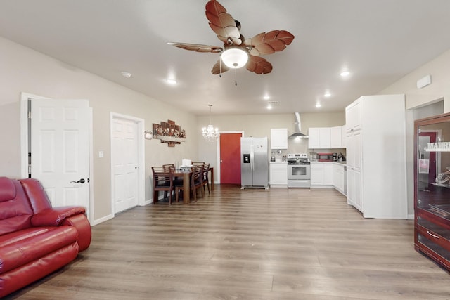 living room with ceiling fan with notable chandelier, baseboards, light wood-style flooring, and recessed lighting