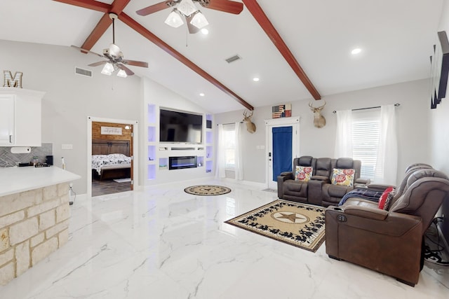 living area featuring lofted ceiling with beams, marble finish floor, a glass covered fireplace, and visible vents