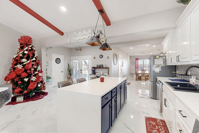 kitchen with white cabinets, a sink, marble finish floor, light countertops, and stainless steel dishwasher