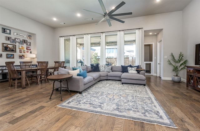 living room featuring ceiling fan and dark hardwood / wood-style flooring