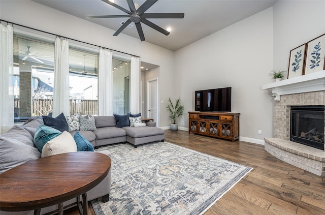 living room with lofted ceiling, hardwood / wood-style flooring, a fireplace, and ceiling fan