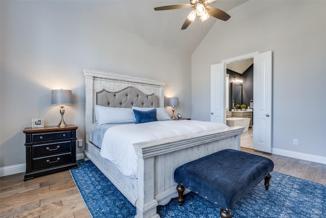 bedroom with ceiling fan, high vaulted ceiling, and ensuite bath