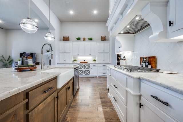 kitchen featuring sink, tasteful backsplash, hanging light fixtures, appliances with stainless steel finishes, and white cabinets