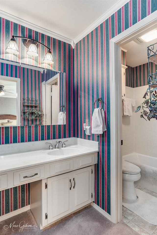 bathroom with ornamental molding, vanity, ceiling fan, toilet, and a bath