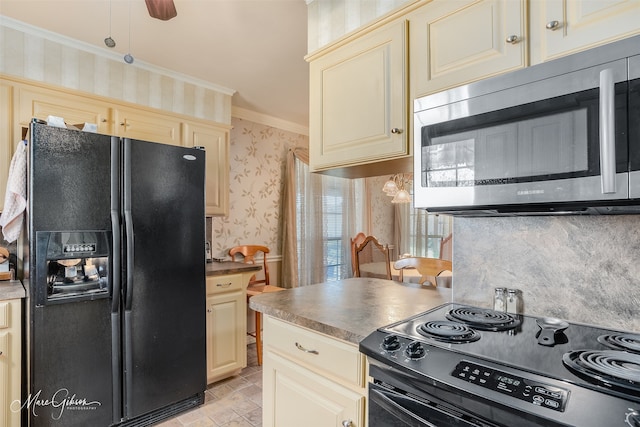 kitchen featuring cream cabinets, ornamental molding, black appliances, and ceiling fan