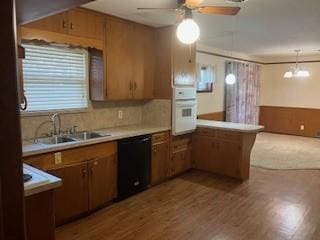 kitchen with sink, oven, black dishwasher, decorative light fixtures, and kitchen peninsula