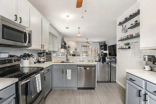 kitchen with gray cabinets, ceiling fan, stainless steel appliances, light hardwood / wood-style floors, and white cabinets