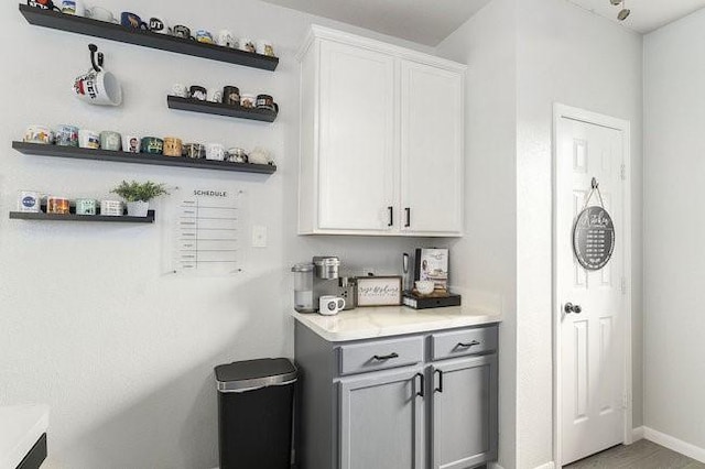 bar featuring gray cabinetry and white cabinets