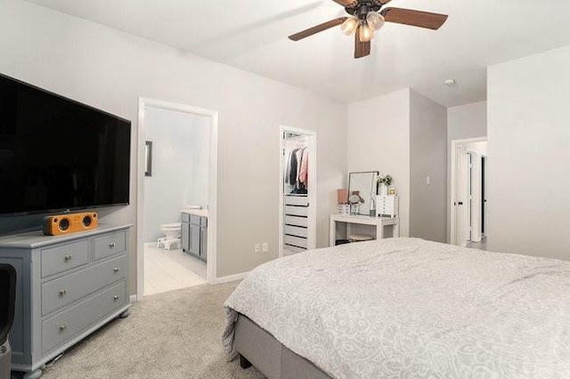 carpeted bedroom featuring connected bathroom, a spacious closet, a closet, and ceiling fan