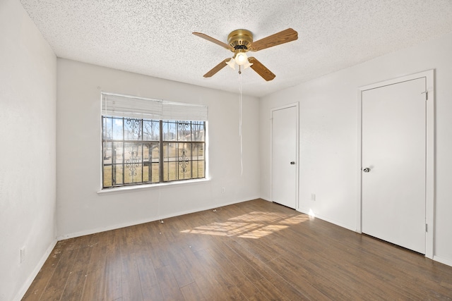 unfurnished bedroom featuring dark hardwood / wood-style flooring, a textured ceiling, and ceiling fan