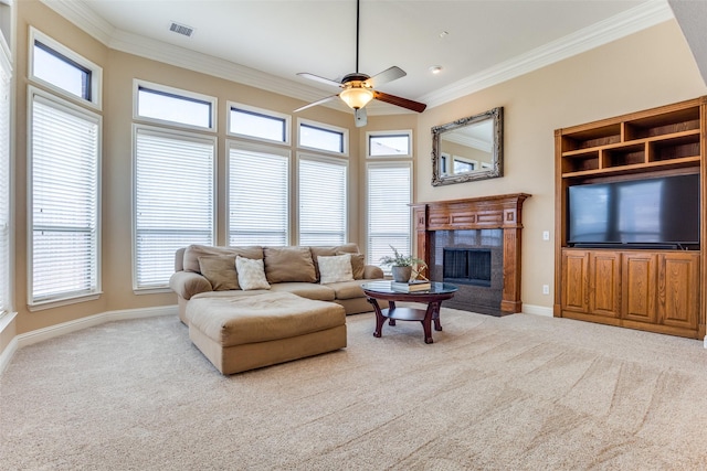 carpeted living room featuring a tiled fireplace, crown molding, and ceiling fan