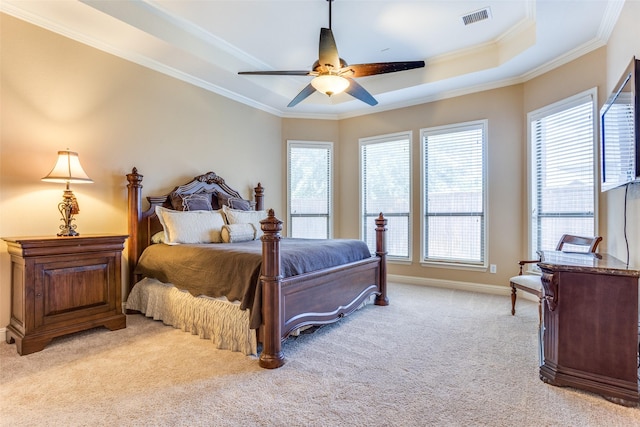 carpeted bedroom featuring crown molding, a tray ceiling, and ceiling fan