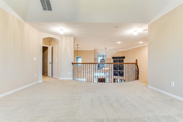 carpeted spare room featuring crown molding