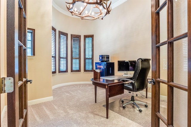 carpeted home office featuring crown molding, plenty of natural light, and a chandelier