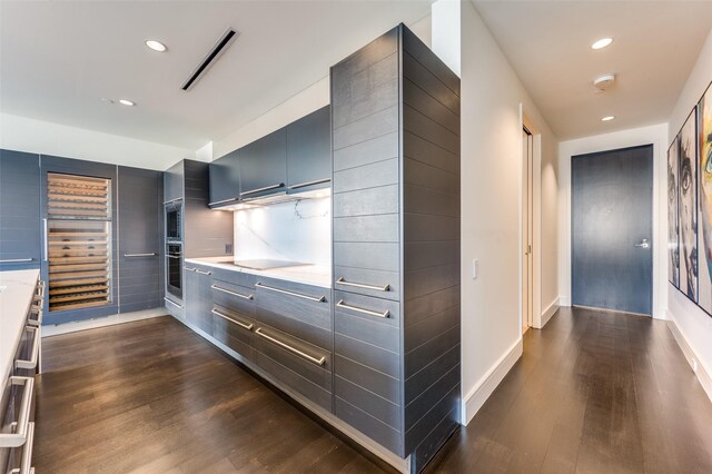 2408 Victory Park Ln Unit 1037, Dallas, TX 75219 - kitchen with dark wood-style flooring, oven, light countertops, recessed lighting, and baseboards