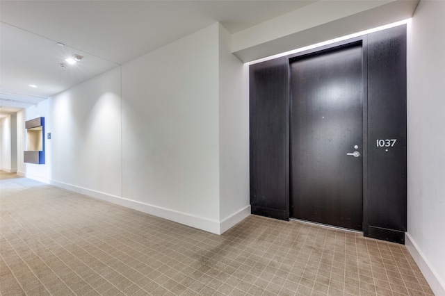 hall with baseboards and recessed lighting