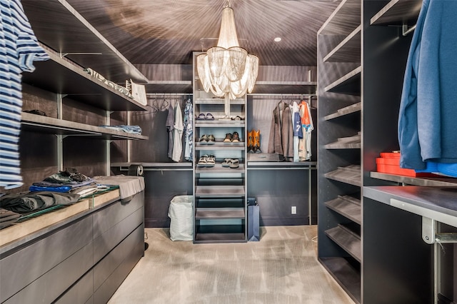 walk in closet featuring a chandelier and carpet