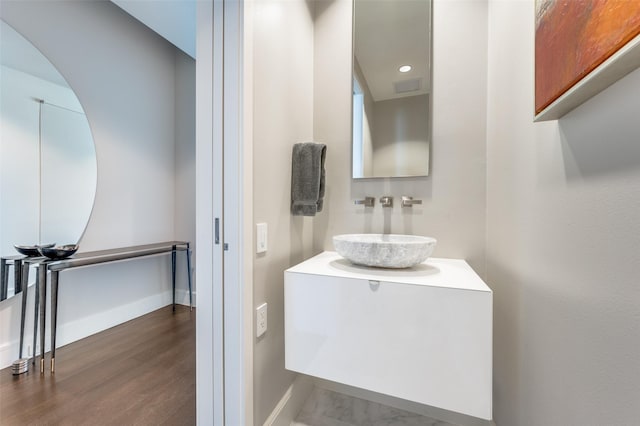 2408 Victory Park Ln Unit 1037, Dallas, TX 75219 - bathroom with vanity, baseboards, and wood finished floors