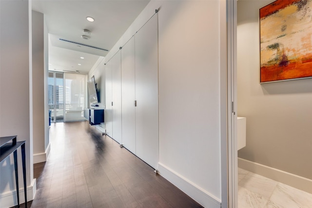 hallway with floor to ceiling windows and light wood-type flooring