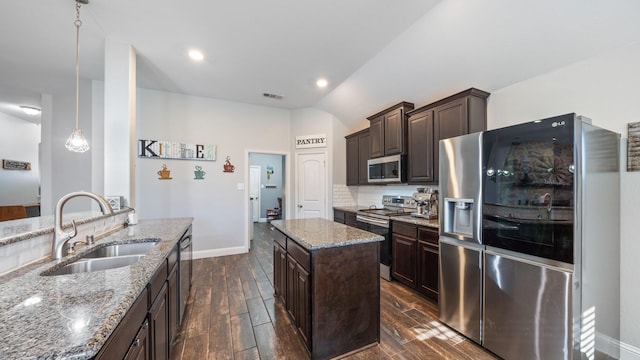 kitchen featuring sink, dark brown cabinets, a kitchen island, pendant lighting, and stainless steel appliances