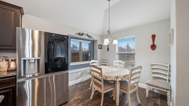 dining room with dark wood-type flooring and vaulted ceiling