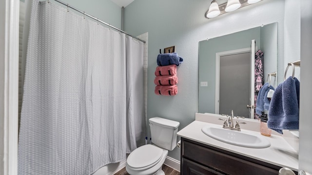 bathroom featuring walk in shower, vanity, and toilet