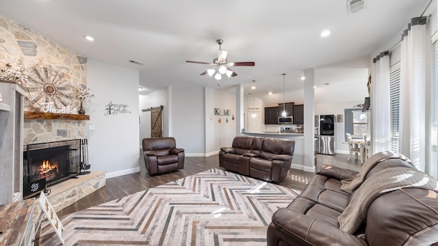 living room with dark hardwood / wood-style flooring, a fireplace, and ceiling fan