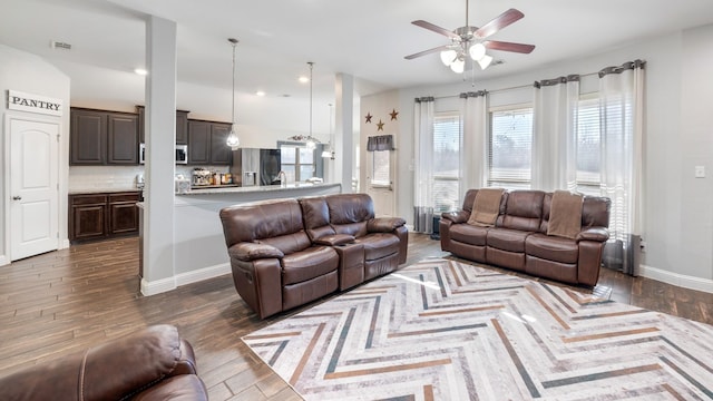 living room with dark wood-type flooring and ceiling fan