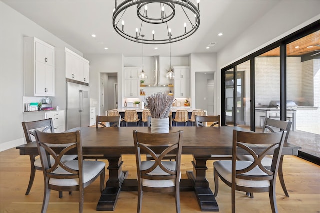 dining room with an inviting chandelier and light hardwood / wood-style flooring