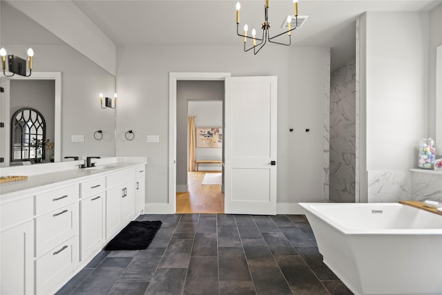 bathroom featuring vanity, a bath, and an inviting chandelier