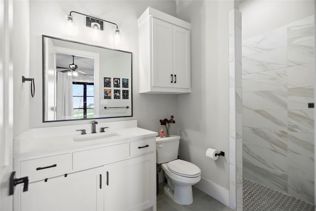 bathroom with vanity, a tile shower, ceiling fan, and toilet