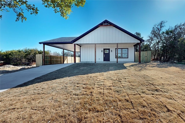 modern farmhouse style home featuring a carport, covered porch, and a front lawn