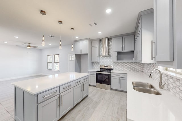 kitchen featuring electric stove, wall chimney range hood, sink, gray cabinets, and tasteful backsplash