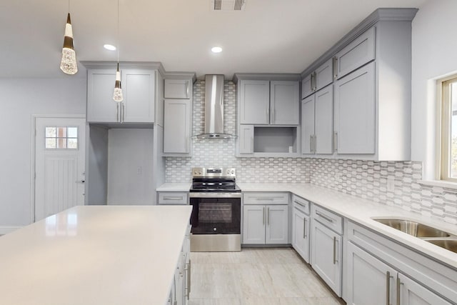 kitchen with stainless steel electric range oven, pendant lighting, gray cabinetry, backsplash, and wall chimney exhaust hood