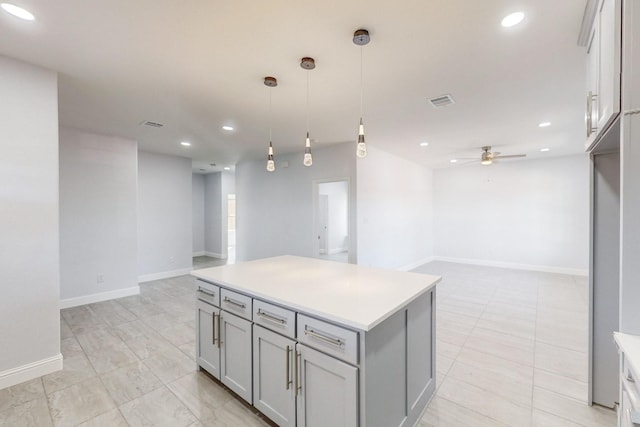 kitchen featuring light tile patterned flooring, gray cabinetry, a center island, hanging light fixtures, and ceiling fan