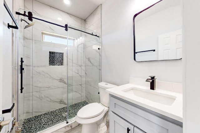 bathroom featuring vanity, toilet, and a shower with shower door