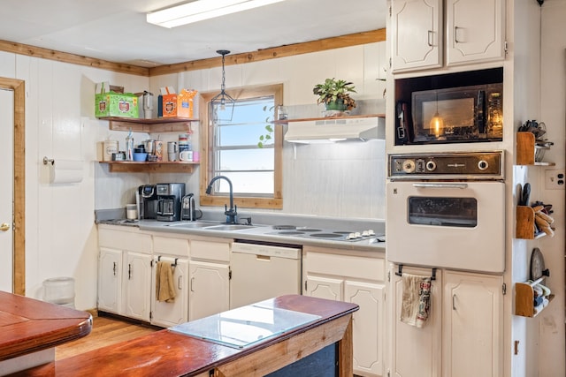 kitchen featuring pendant lighting, white cabinetry, sink, light wood-type flooring, and white appliances