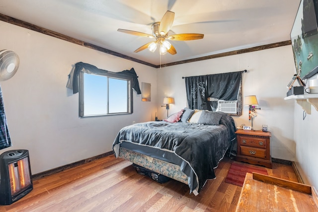 bedroom featuring hardwood / wood-style flooring, ceiling fan, ornamental molding, and cooling unit