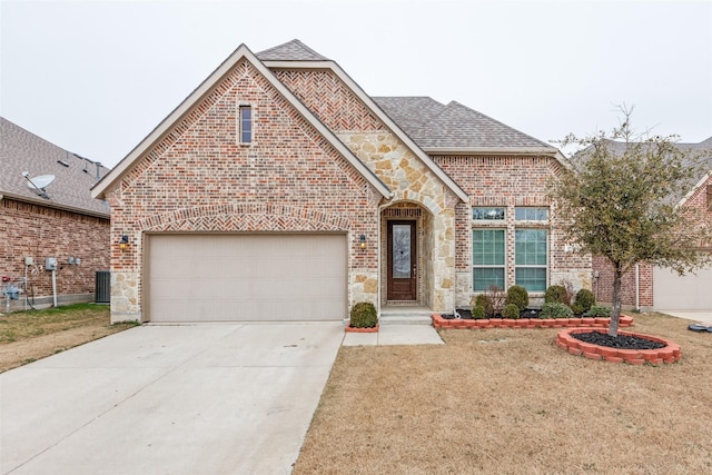 front facade featuring cooling unit, a garage, and a front yard