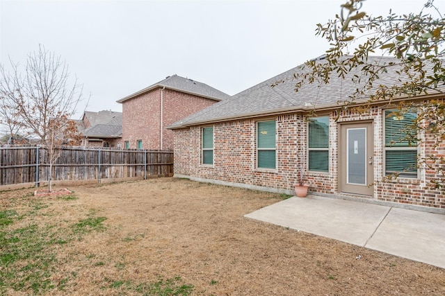 rear view of property with a yard and a patio area