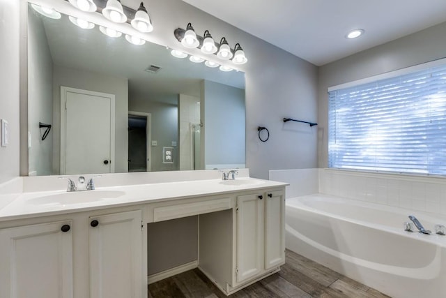 bathroom with independent shower and bath, vanity, and hardwood / wood-style floors