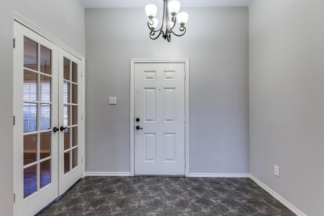 foyer featuring french doors and a notable chandelier