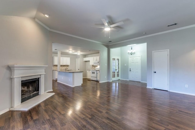 unfurnished living room with crown molding, lofted ceiling, dark hardwood / wood-style flooring, and ceiling fan with notable chandelier