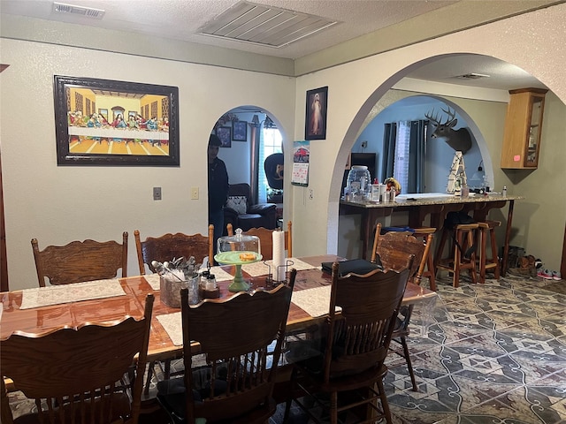 dining room with visible vents and a textured ceiling