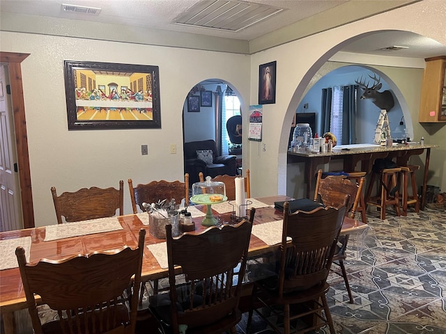 dining room with arched walkways and visible vents