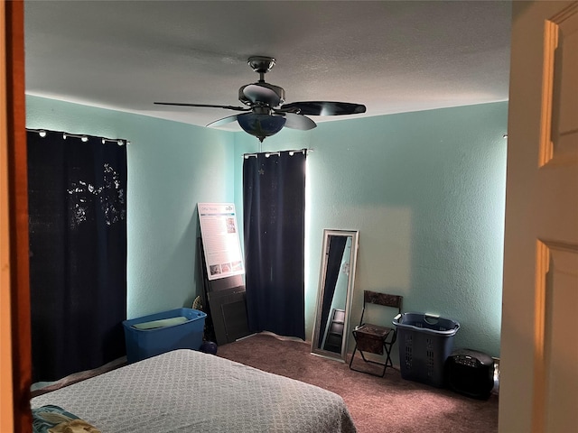 carpeted bedroom featuring a textured wall and a ceiling fan