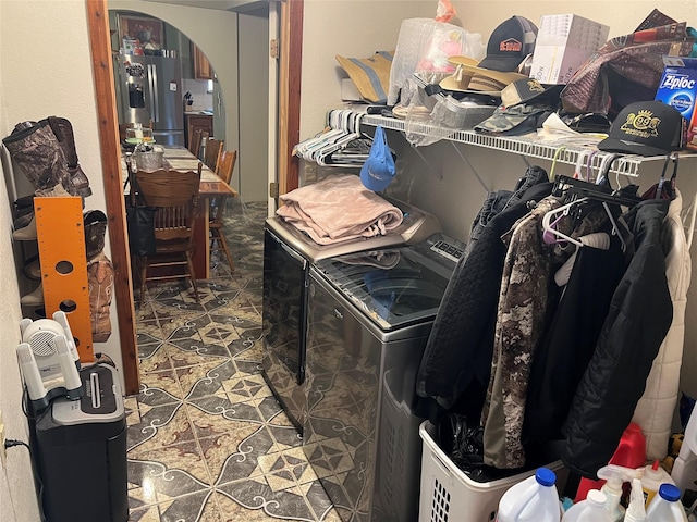 walk in closet featuring arched walkways and independent washer and dryer