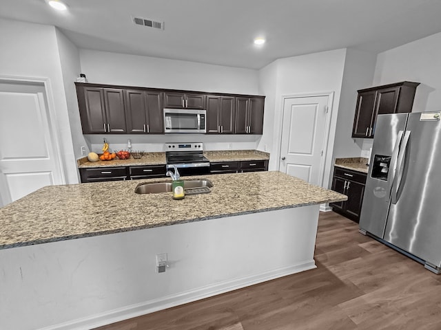 6668 Fitzgerald St, Fort Worth, TX 76179 - kitchen featuring appliances with stainless steel finishes, a sink, dark wood-style flooring, light stone countertops, and dark brown cabinetry