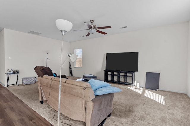 carpeted living area with baseboards, visible vents, and a ceiling fan